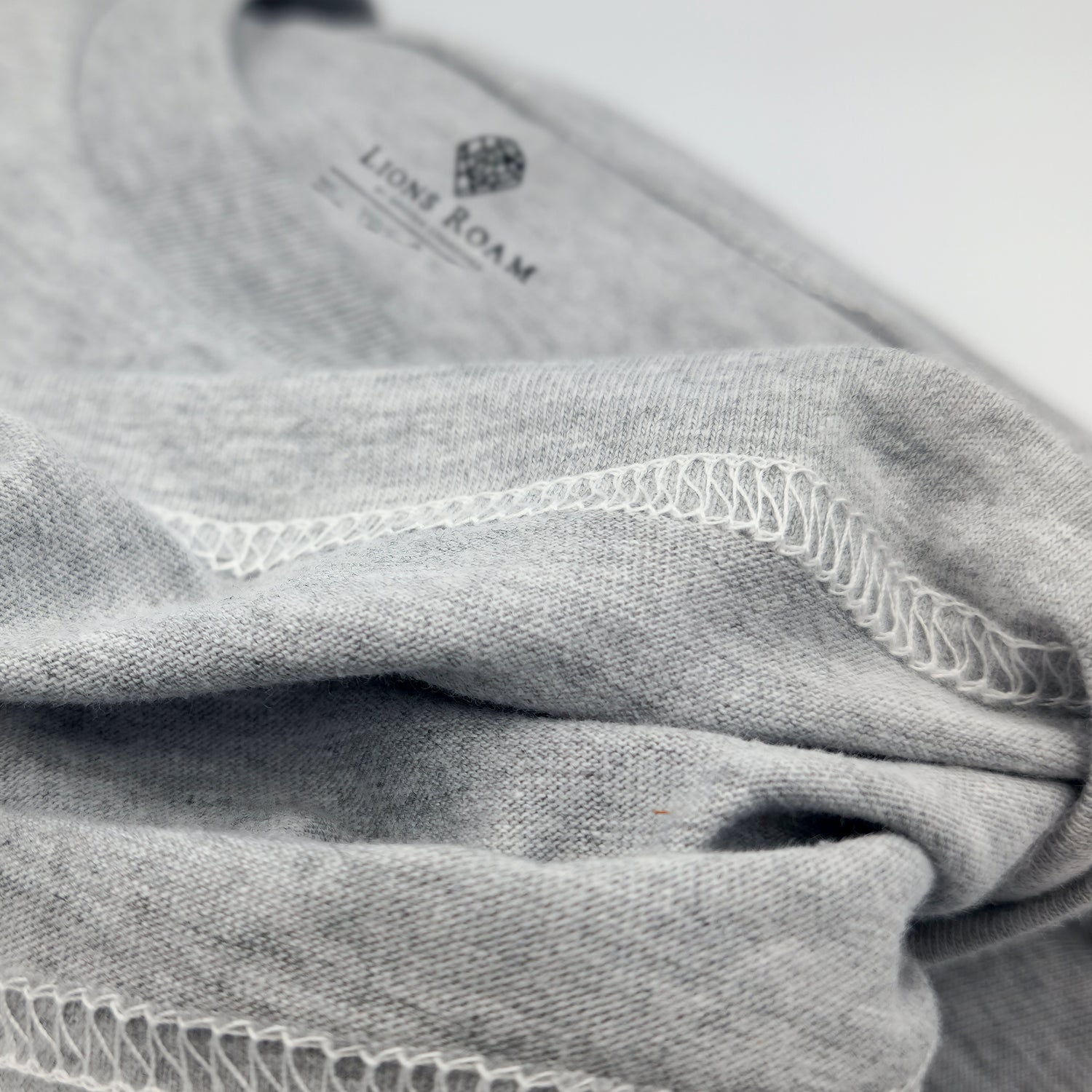 Lions Roam clothing tag on a grey t shirt showing the double stitched seam
