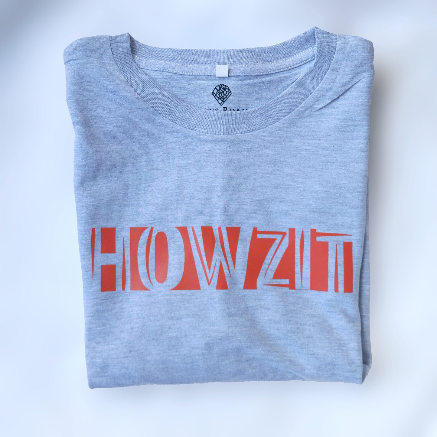 A Grey t-shirt with the phrase "Howzit" printed in Red.