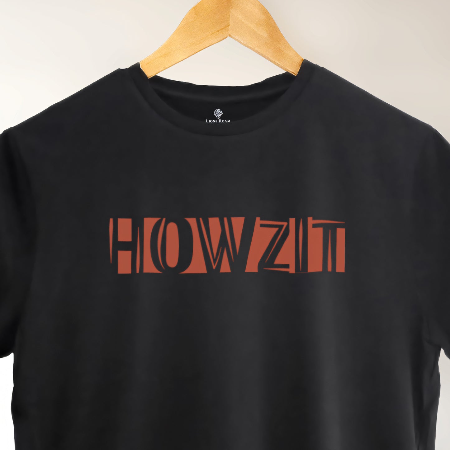 A black t-shirt with the phrase "Howzit" printed in Red.
