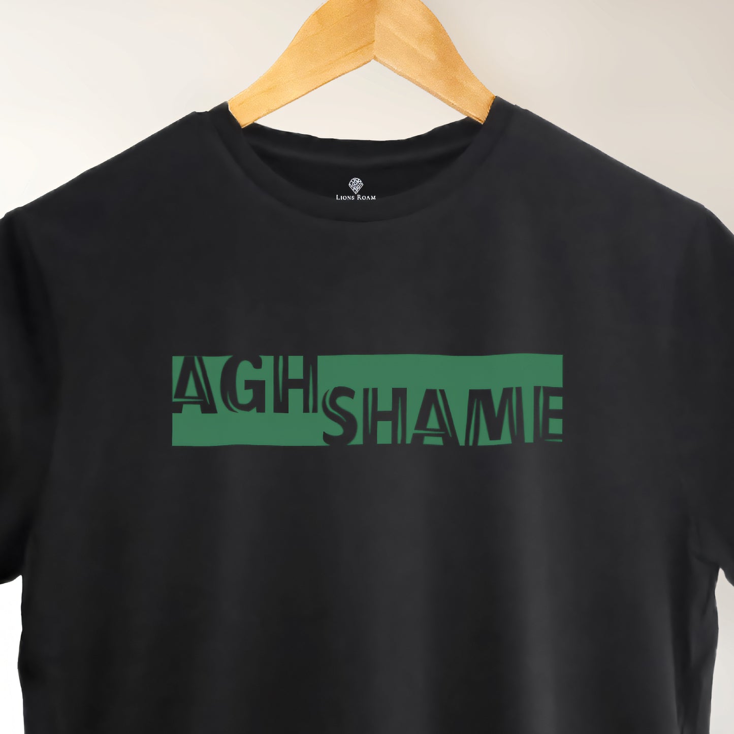 A black t-shirt with the phrase "Agh Shame" printed in Green.