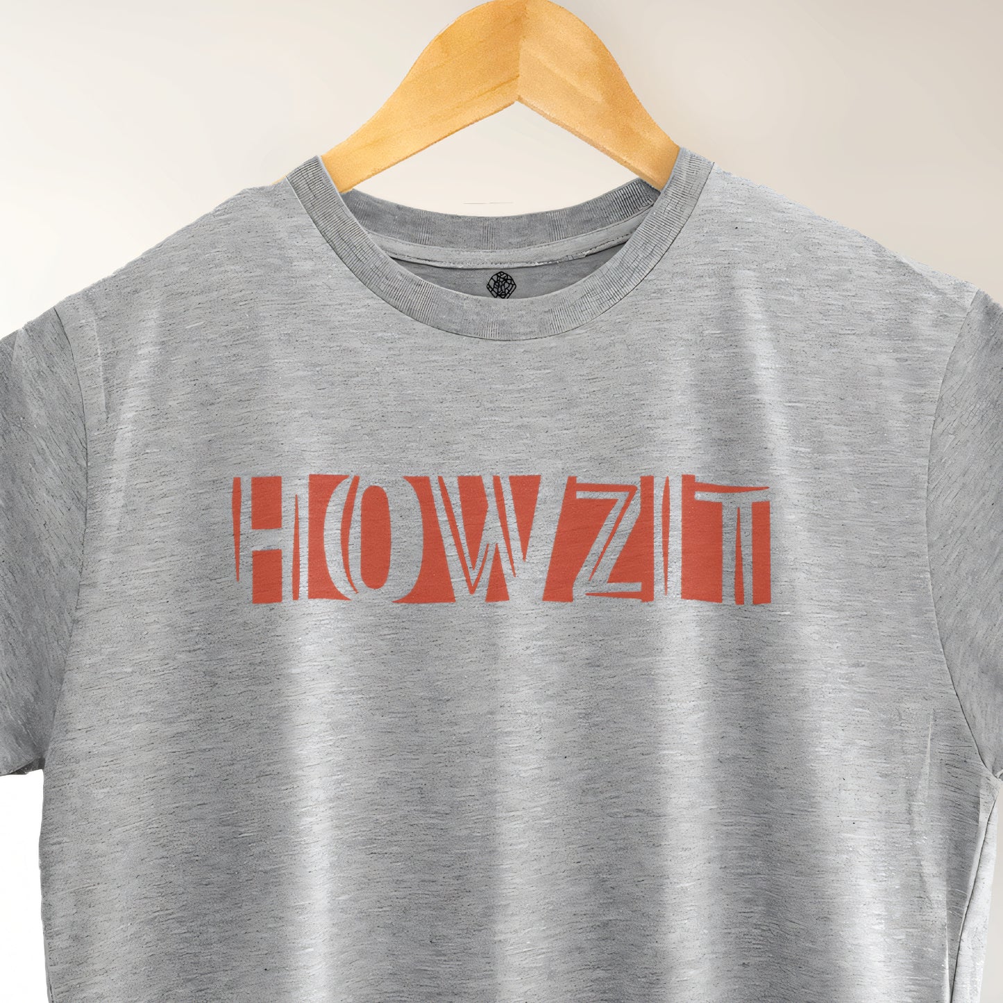A Grey t-shirt with the phrase "Howzit" printed in Red.