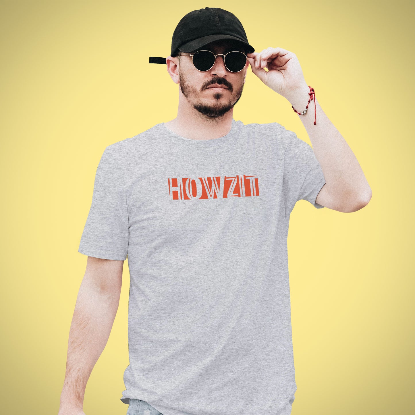 A Grey t-shirt with the phrase "Howzit" printed in Red.