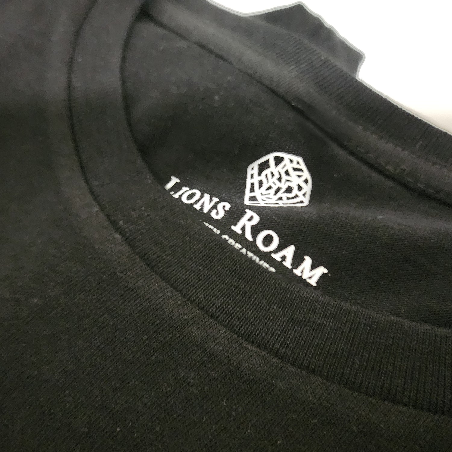 Black Lions Roam clothing tag on a black t shirt