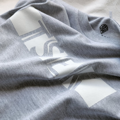 A Grey t-shirt with the phrase "Tsek" printed in White.