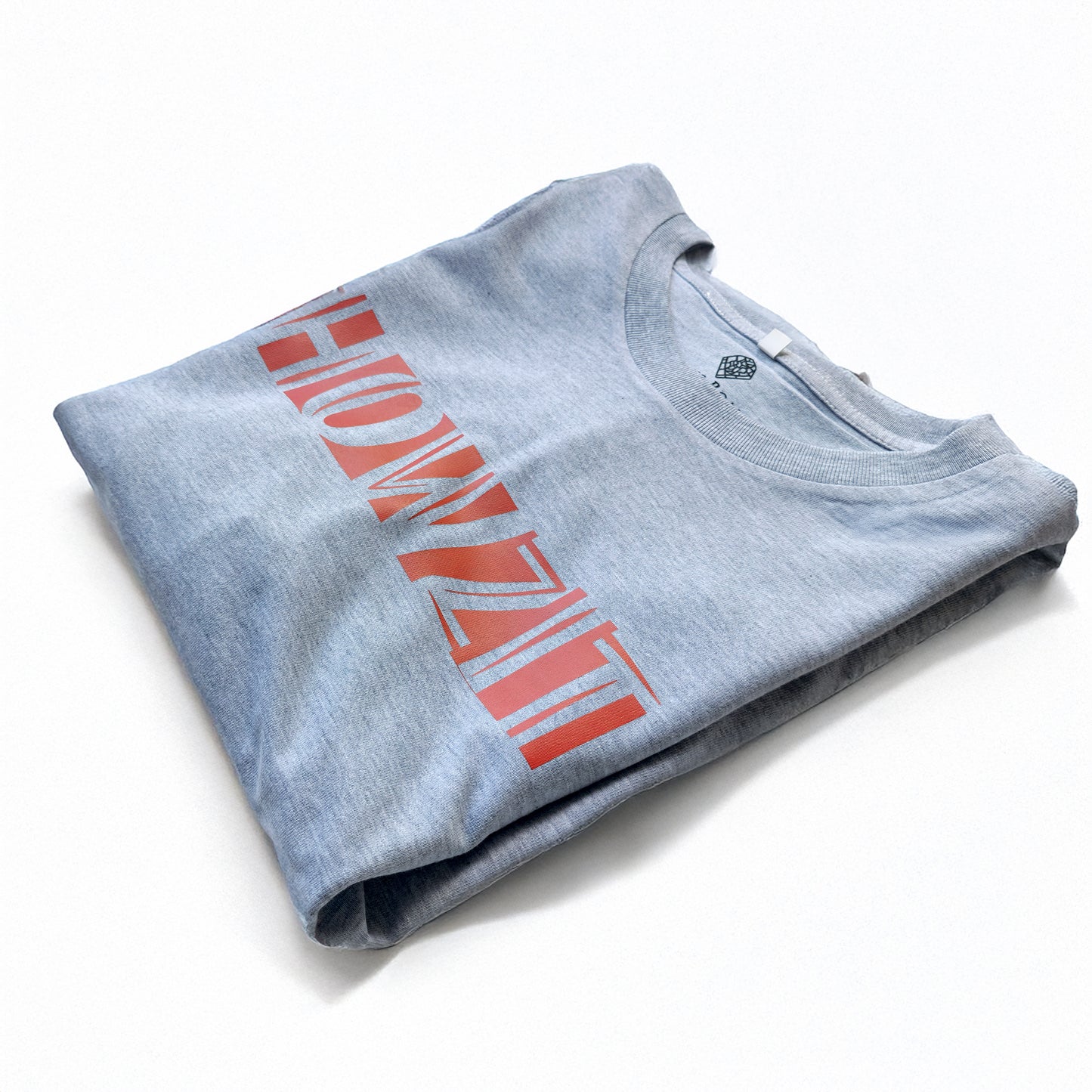 A Grey t-shirt with the phrase "Howzit" printed in Red.