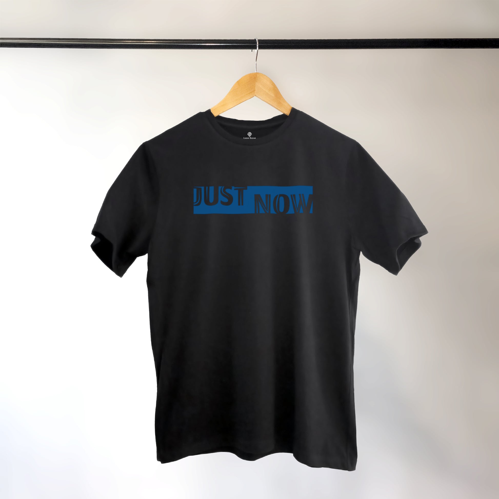 A black t-shirt with the phrase "Just Now" printed in Blue.