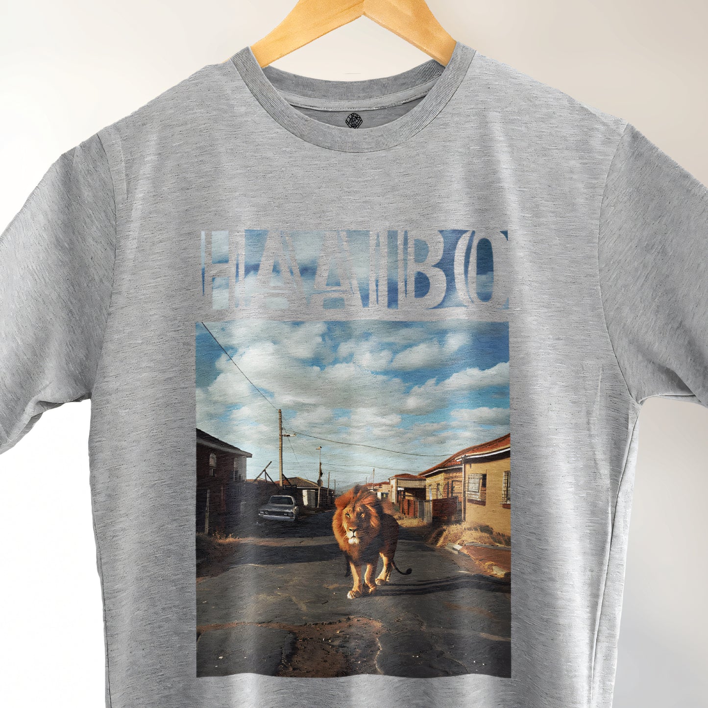 A Grey t-shirt with the phrase "Haaibo" printed in the sky, with a lion roaming the streets of africa.