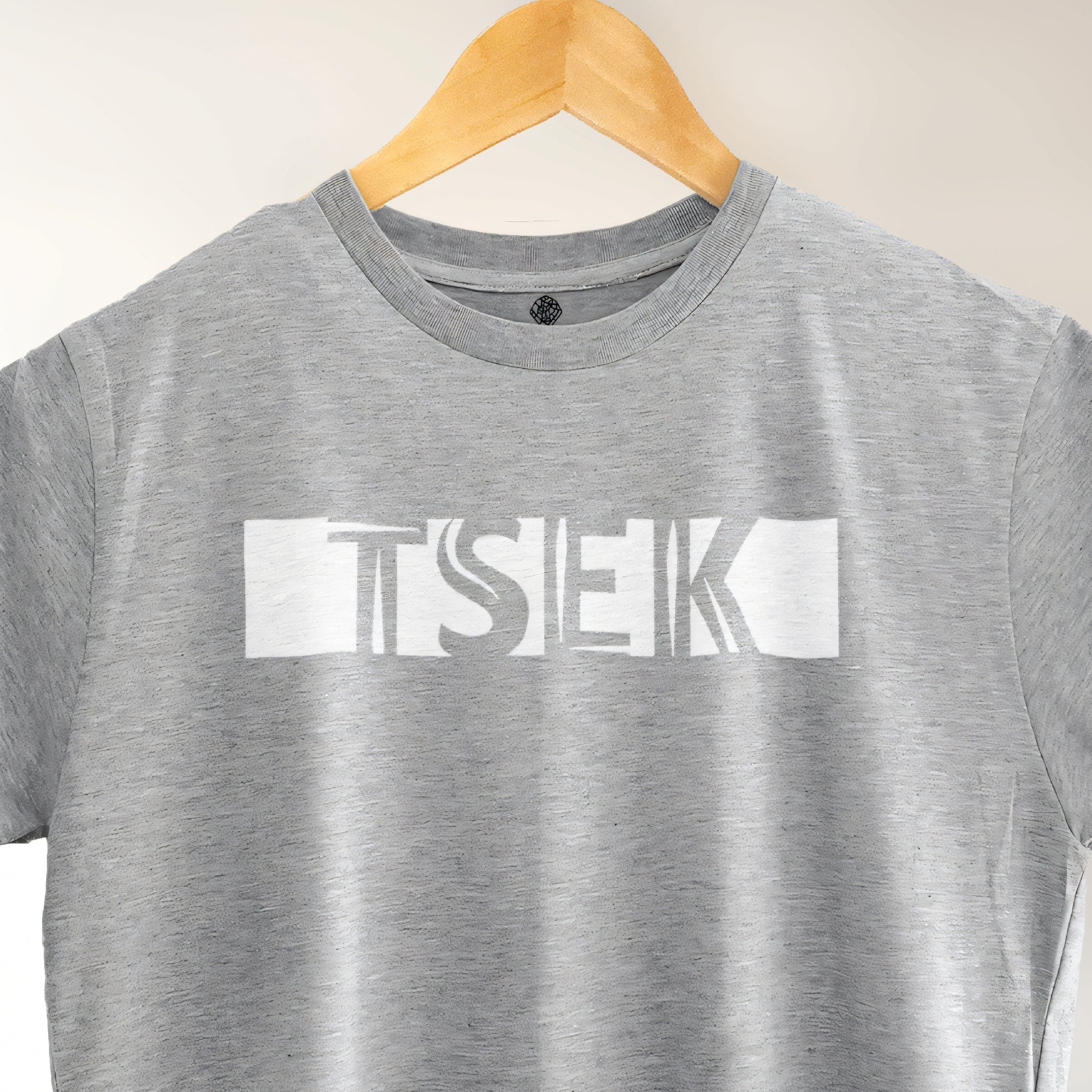A Grey t-shirt with the phrase "Tsek" printed in White.