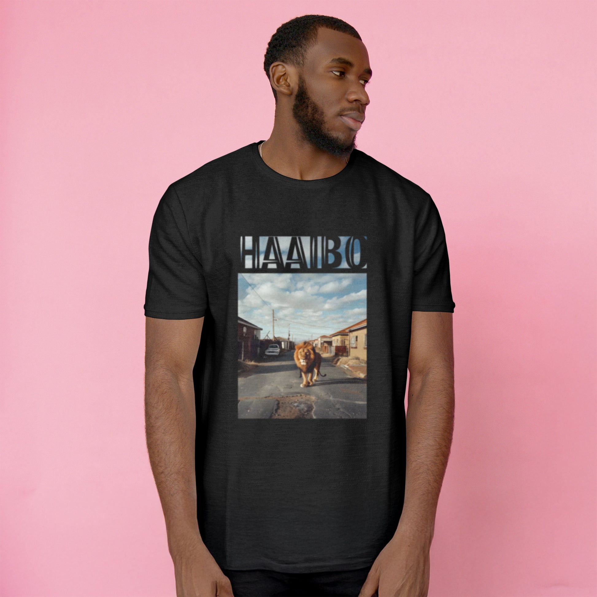 A Black t-shirt with the phrase "Haaibo" printed in the sky, with a lion roaming the streets of africa.