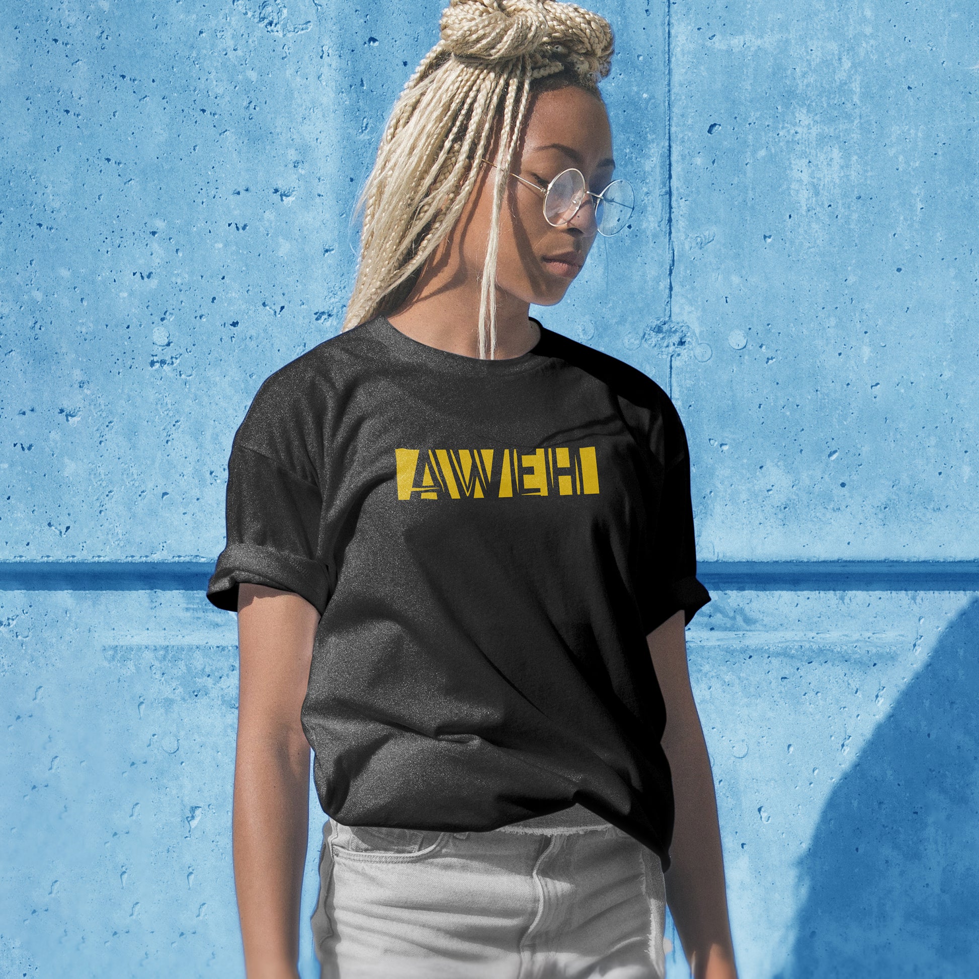 A black t-shirt with the phrase "Aweh" printed in Yellow.